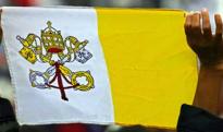 A Vatican flag is held aloft